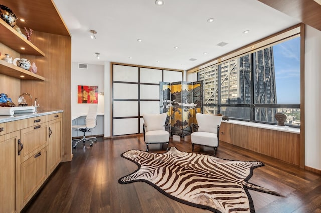 sitting room featuring dark wood finished floors, expansive windows, and visible vents