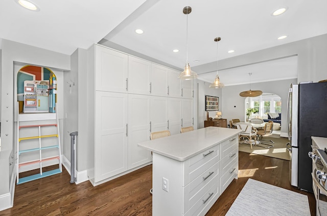 kitchen with light countertops, dark wood-style flooring, a kitchen island, and white cabinetry