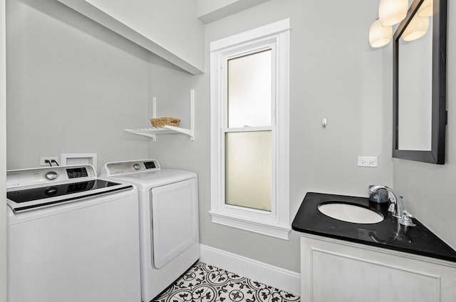 laundry room with a sink, independent washer and dryer, tile patterned floors, and baseboards
