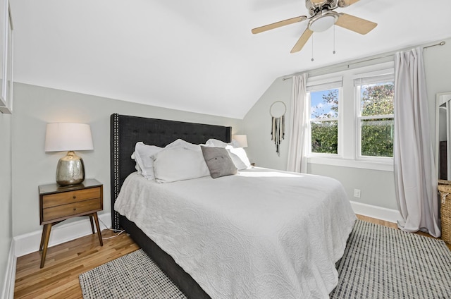 bedroom with lofted ceiling, a ceiling fan, light wood-style flooring, and baseboards