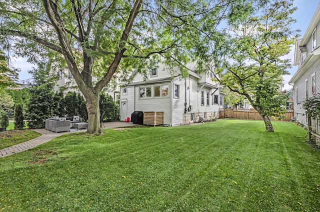 view of yard featuring a patio, an outdoor living space, and a fenced backyard