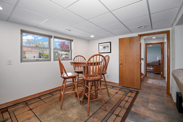 dining space with recessed lighting, a paneled ceiling, and baseboards