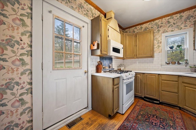 kitchen with visible vents, white appliances, light wood-type flooring, crown molding, and tasteful backsplash