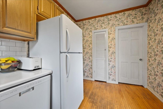 kitchen featuring wallpapered walls, ornamental molding, white appliances, baseboards, and light wood-style flooring