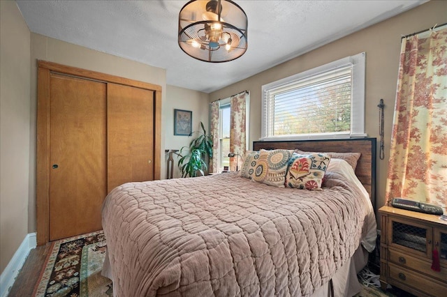 bedroom featuring wood finished floors, a closet, and baseboards
