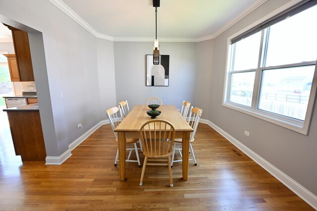 661 Bluebonnett Dr, Aurora, IL 60505 - dining room with baseboards, healthy amount of natural light, light wood-style floors, and ornamental molding