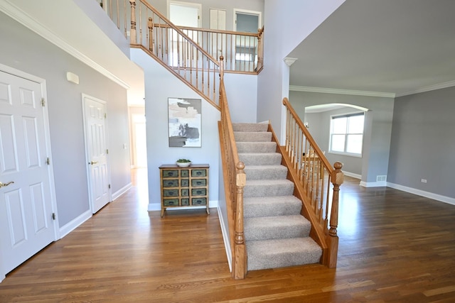 661 Bluebonnett Dr, Aurora, IL 60505 - stairs featuring arched walkways, wood finished floors, baseboards, crown molding, and a high ceiling
