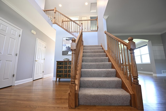 661 Bluebonnett Dr, Aurora, IL 60505 - stairway with baseboards, wood finished floors, crown molding, arched walkways, and recessed lighting