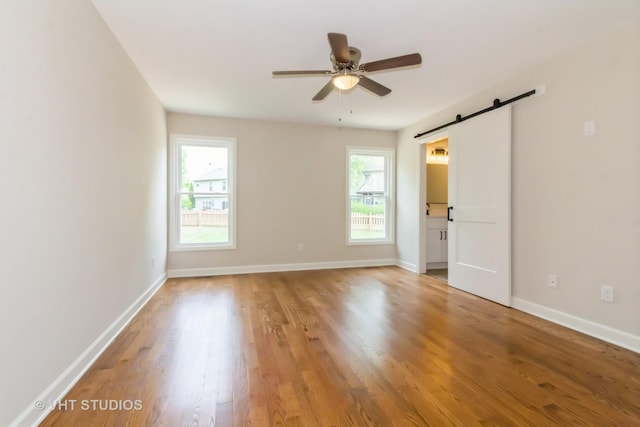 2509 Oak Trails Dr, Aurora, IL 60506 - empty room with a barn door, a ceiling fan, and light wood-type flooring
