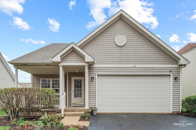 204 Fairwind Dr, Montgomery, IL 60538 - view of front of property with a garage, driveway, covered porch, and roof with shingles