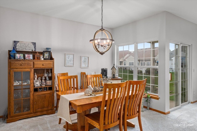204 Fairwind Dr, Montgomery, IL 60538 - dining area featuring baseboards, light carpet, and an inviting chandelier