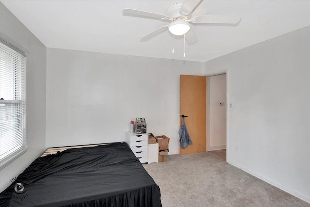 carpeted bedroom featuring baseboards and a ceiling fan