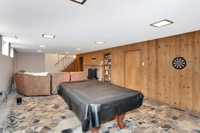 game room with wood walls, billiards, a fireplace, and stone floors