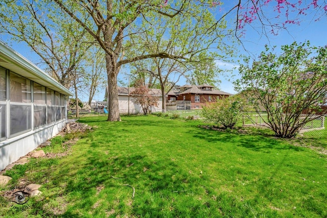 view of yard featuring a fenced backyard and a sunroom