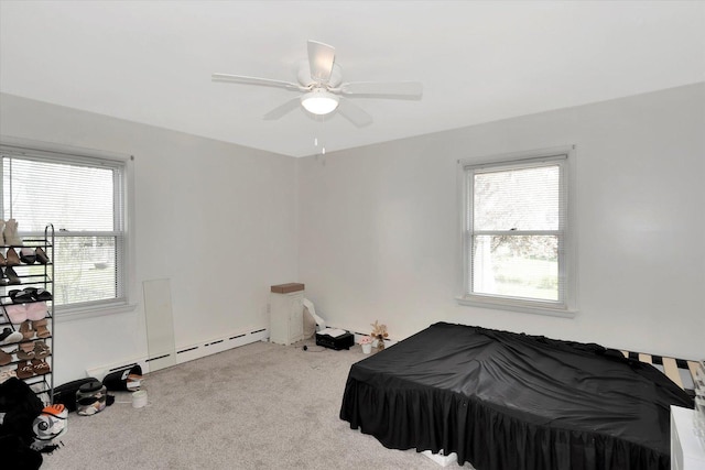 carpeted bedroom featuring ceiling fan, a baseboard heating unit, and multiple windows