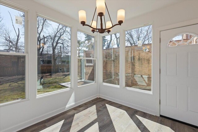 7241 N Kilpatrick Ave, Lincolnwood, IL 60712 - unfurnished sunroom with plenty of natural light, baseboards, wood finished floors, and a notable chandelier