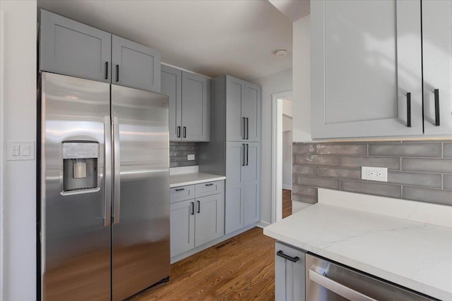 7241 N Kilpatrick Ave, Lincolnwood, IL 60712 - kitchen with wood finished floors, appliances with stainless steel finishes, decorative backsplash, and gray cabinetry