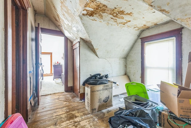 additional living space with wood-type flooring and vaulted ceiling