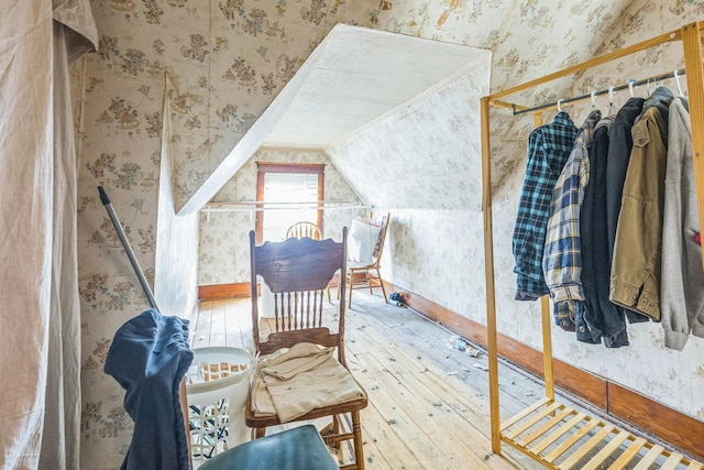 bonus room with lofted ceiling, wallpapered walls, and hardwood / wood-style flooring