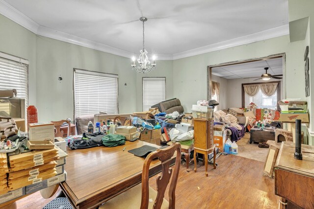 dining area with crown molding, ceiling fan with notable chandelier, and light wood-style flooring
