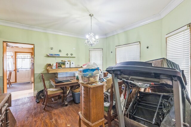 dining area with ornamental molding, a healthy amount of sunlight, a chandelier, and wood finished floors