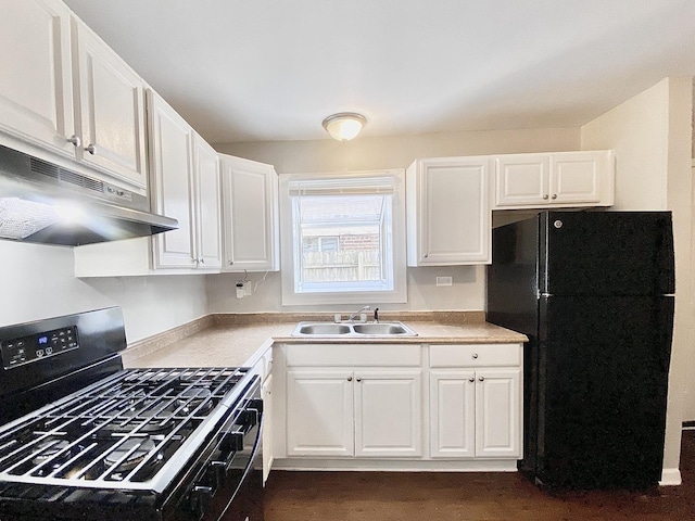 kitchen with white cabinets, under cabinet range hood, a sink, and black appliances