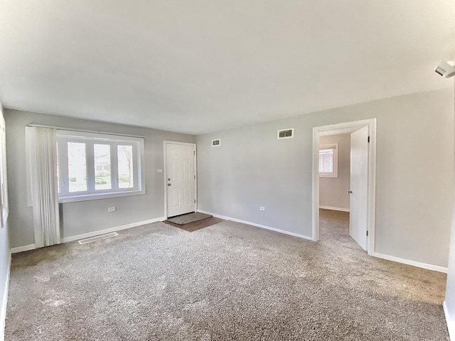 carpeted empty room with visible vents and baseboards