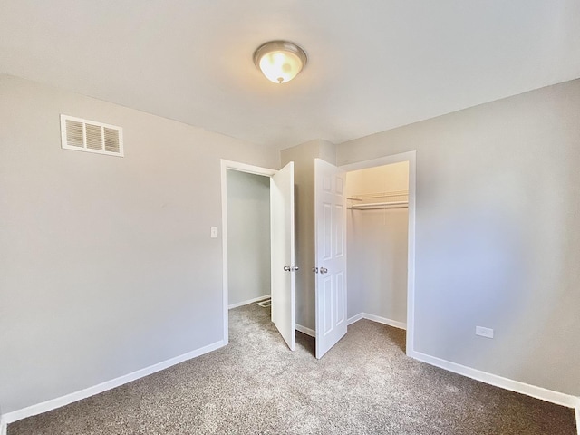 unfurnished bedroom with a closet, carpet, visible vents, and baseboards