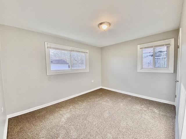 empty room featuring baseboards and carpet flooring