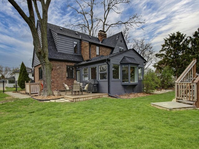 517 S Washington St, Wheaton, IL 60187 - rear view of house with a wooden deck, a lawn, a chimney, and brick siding