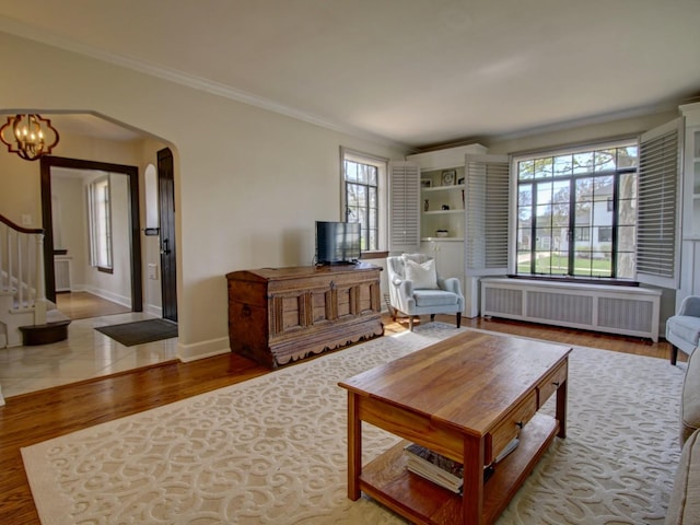 517 S Washington St, Wheaton, IL 60187 - living area with arched walkways, radiator, wood finished floors, stairs, and ornamental molding