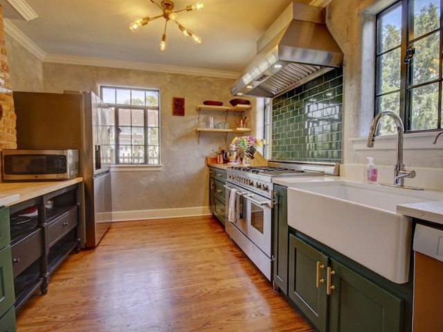 517 S Washington St, Wheaton, IL 60187 - kitchen featuring wood finished floors, a sink, island range hood, baseboards, and appliances with stainless steel finishes