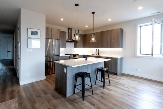 117 S Bell Ave Unit 4S, Chicago, IL 60612 - kitchen with stainless steel appliances, wall chimney range hood, a kitchen breakfast bar, a center island, and modern cabinets