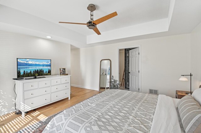 bedroom featuring visible vents, light wood-style floors, ceiling fan, recessed lighting, and a raised ceiling