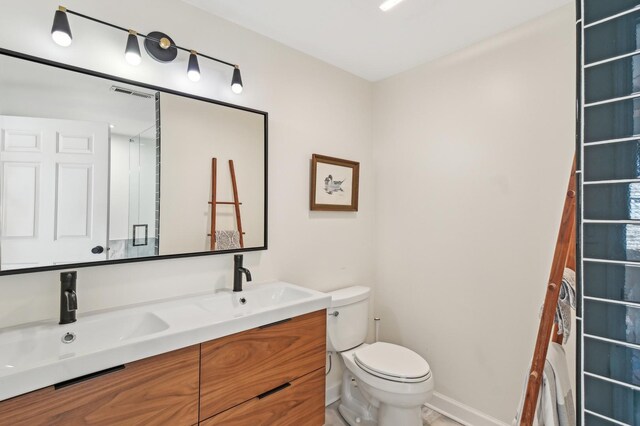 bathroom with double vanity, a sink, visible vents, and toilet
