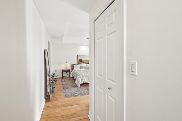 hallway featuring light wood-type flooring and baseboards