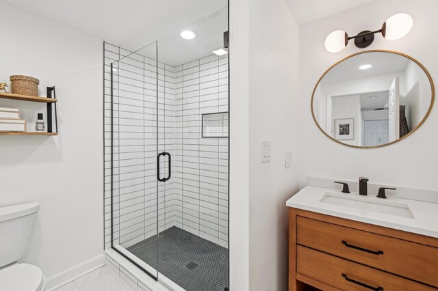 bathroom featuring vanity, marble finish floor, toilet, baseboards, and a shower stall