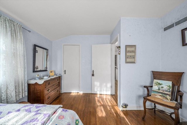 bedroom with baseboards, vaulted ceiling, and dark wood-style floors