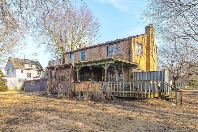 rear view of property featuring a chimney and a deck