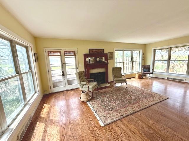 living area featuring visible vents, wood finished floors, and a fireplace