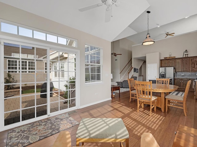 1683 Briarheath Dr, Aurora, IL 60505 - dining space featuring a ceiling fan, stairway, high vaulted ceiling, baseboards, and light wood finished floors