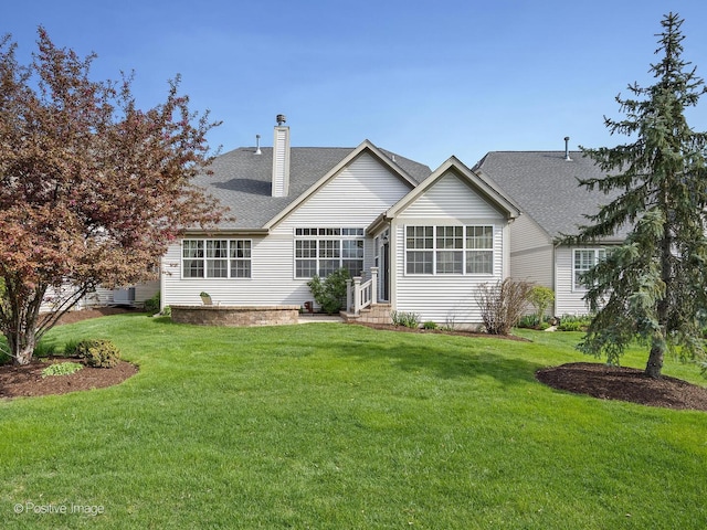 1683 Briarheath Dr, Aurora, IL 60505 - back of house featuring entry steps, a chimney, a yard, and a shingled roof
