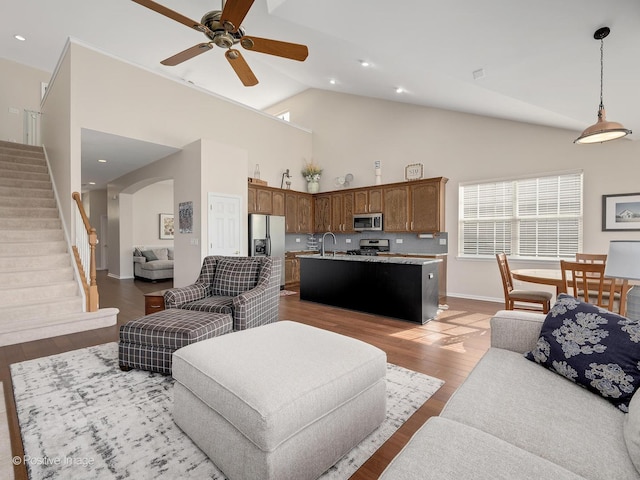 1683 Briarheath Dr, Aurora, IL 60505 - living area with stairs, high vaulted ceiling, arched walkways, a ceiling fan, and light wood-style flooring