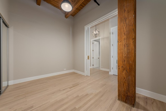 interior space with beamed ceiling, light wood-style flooring, baseboards, and wood ceiling