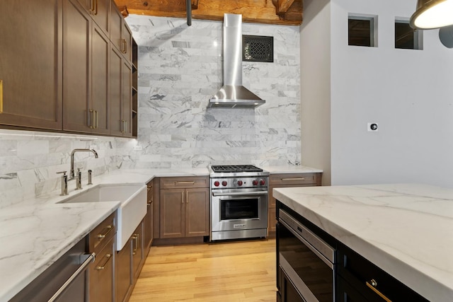 kitchen featuring tasteful backsplash, light stone countertops, appliances with stainless steel finishes, and light wood-style flooring