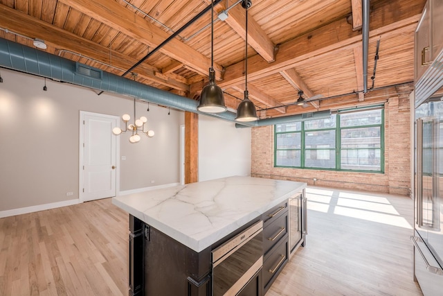 kitchen featuring light wood-style floors, decorative light fixtures, wood ceiling, and built in appliances