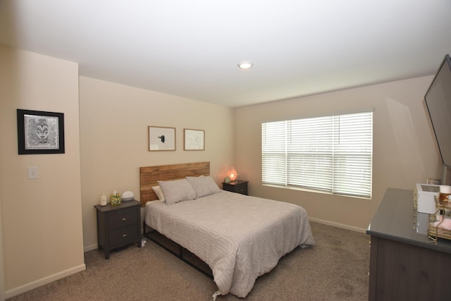 bedroom featuring light carpet and baseboards
