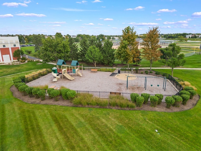 community play area with a lawn and fence