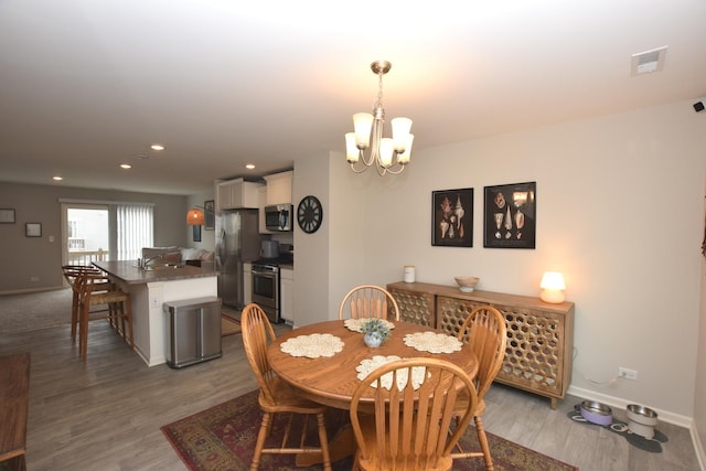 dining room with visible vents, baseboards, recessed lighting, a chandelier, and wood finished floors