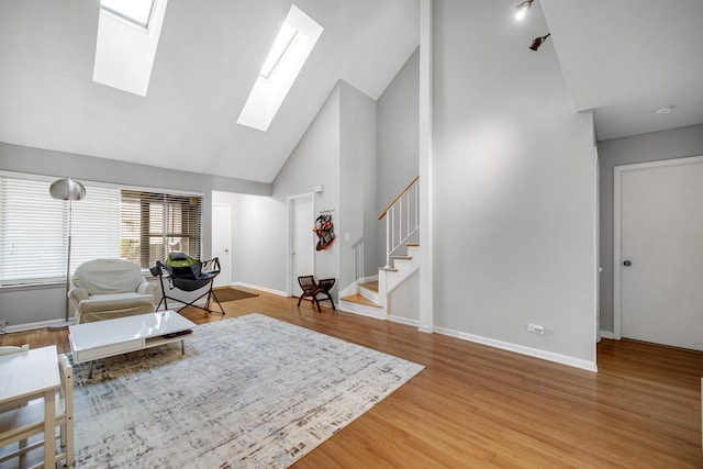 791 Overland Ct, Roselle, IL 60172 - living room featuring wood finished floors, baseboards, high vaulted ceiling, stairway, and a skylight